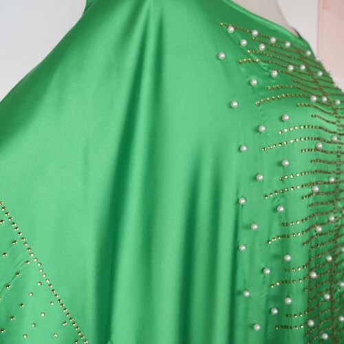 Green fabric adorned with pearl-like beads and gold accents.