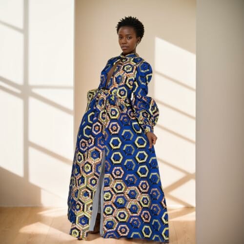 Woman wearing a long dress with geometric patterns, standing indoors.